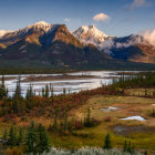 Snow-capped peaks and autumn forests by meandering river