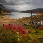 Scenic autumn landscape: lake, mountains, colorful trees, dramatic sky