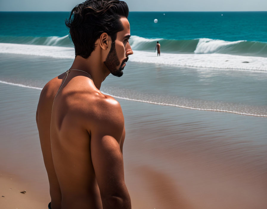 Shirtless man gazing at person walking on beach by the sea