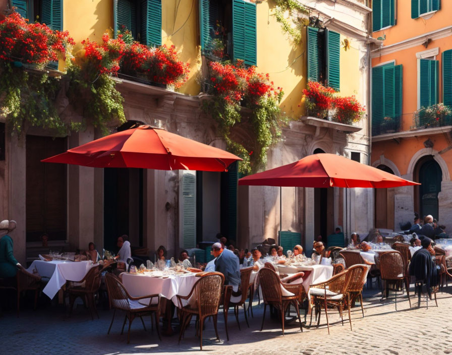 Outdoor restaurant scene with red umbrellas, guests dining, green shutters, and red flowers