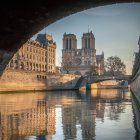 Sleek, Curved Futuristic Architecture Reflecting Warm Light by Water at Dusk