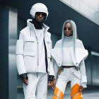 Futuristic individuals in white outfits with helmets and sleek designs