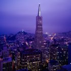 Neon-lit skyscrapers in futuristic city skyline at twilight