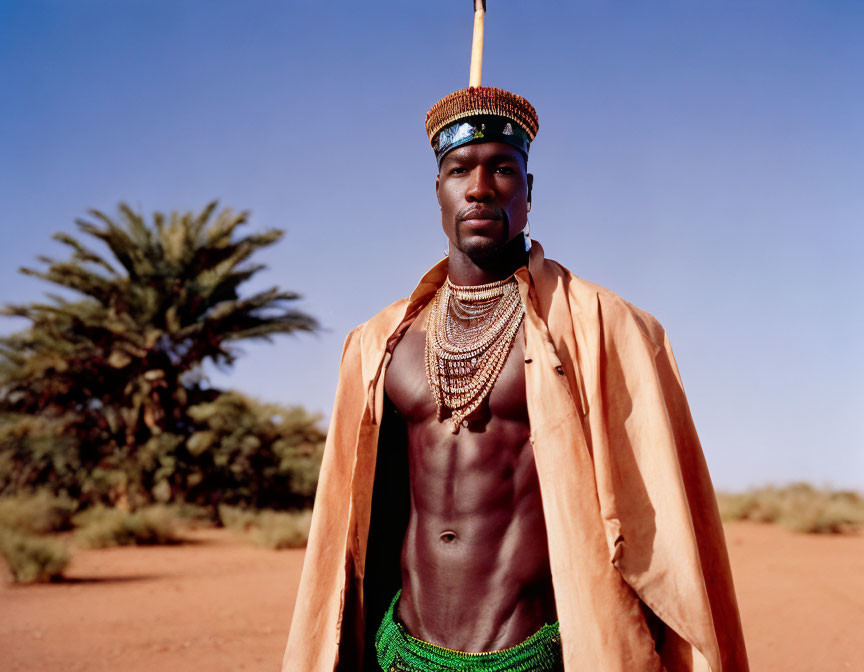 Man in Crown Stands in Desert Setting with Palm Trees