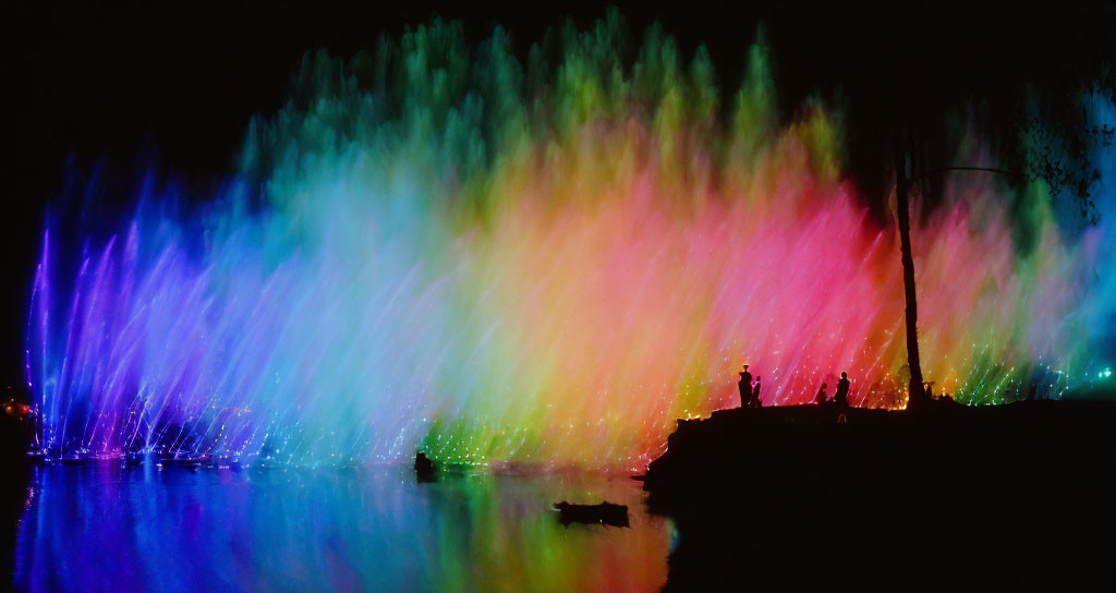 Colorful Night Water Light Show with Silhouettes and Reflections