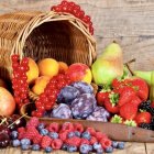 Fresh Fruits Spilling from Wicker Basket on Wooden Surface