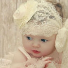 Blue-eyed baby in beige lace headband and outfit on patterned backdrop