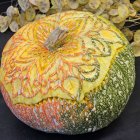 Intricate Gold Filigree Pumpkin with Autumn Leaves on Dark Background