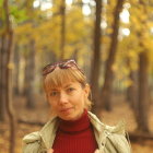 Woman with Autumn Leaves in Hair Standing in Golden Fall Forest