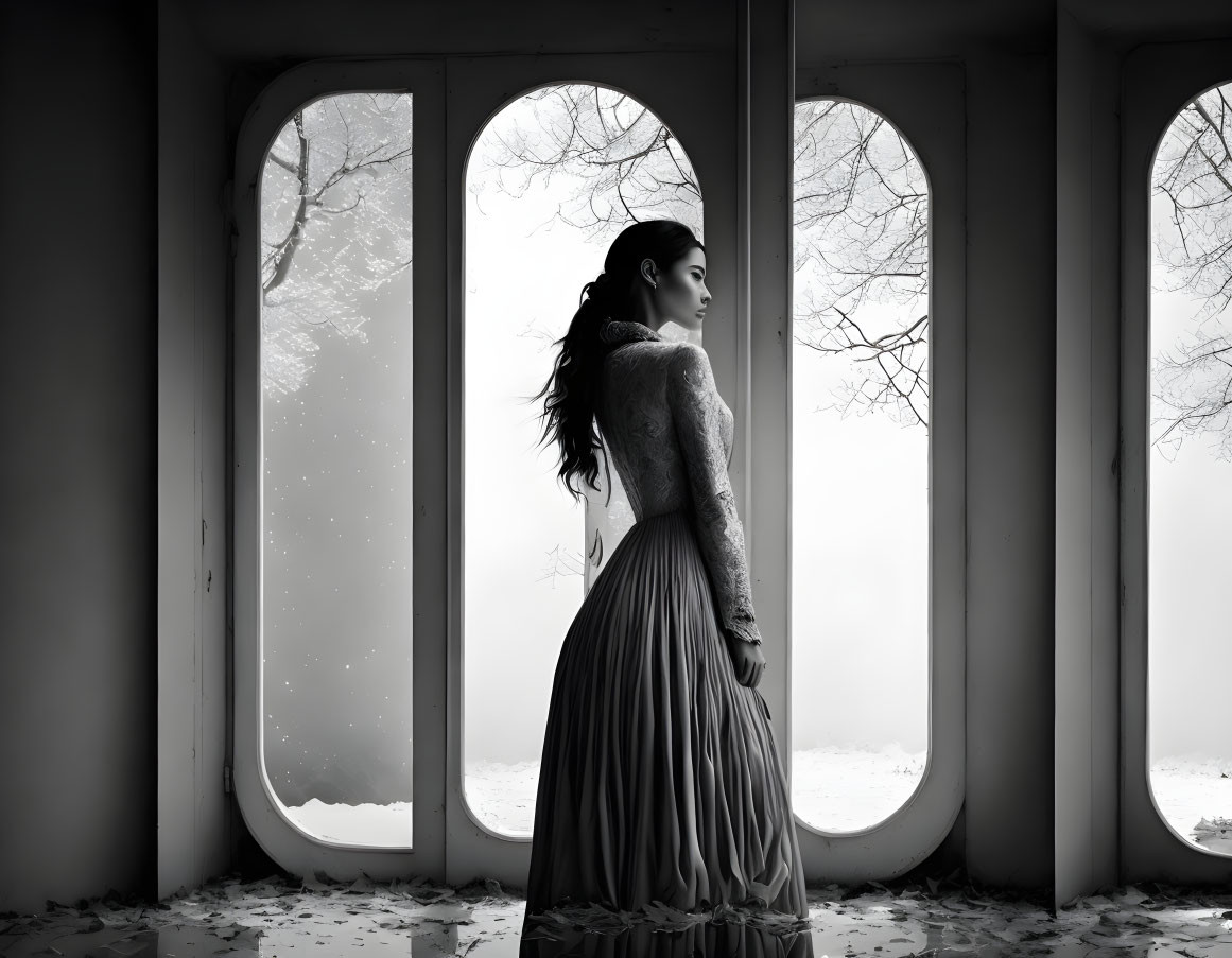 Woman in elegant dress gazes at snowy landscape by large windows