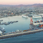 Aerial view of coastal city with burning bridge and ship.