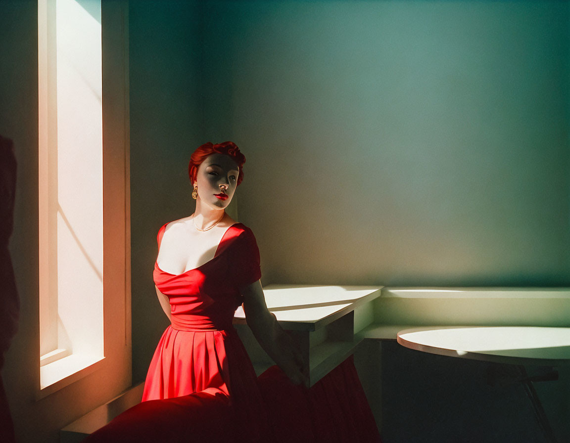 Woman in Red Dress and Headscarf Standing by White Table in Dramatic Light