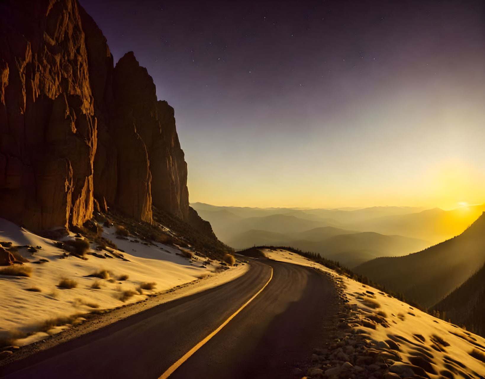 Twilight mountain road with snowy edges under starry sky