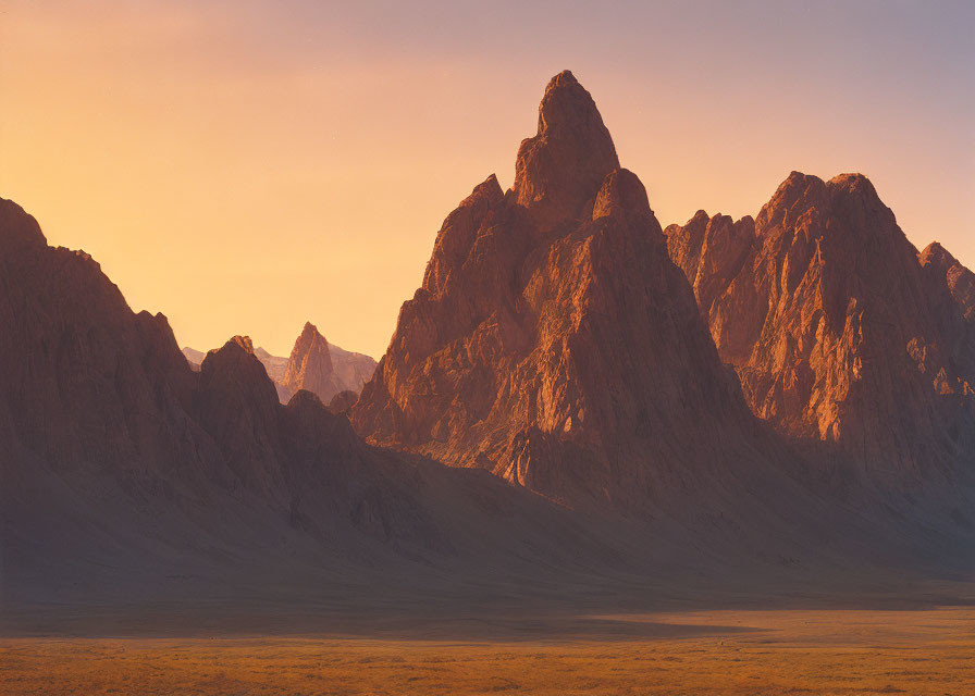 Sunset illuminating mountain peaks and desert plains in serene scene