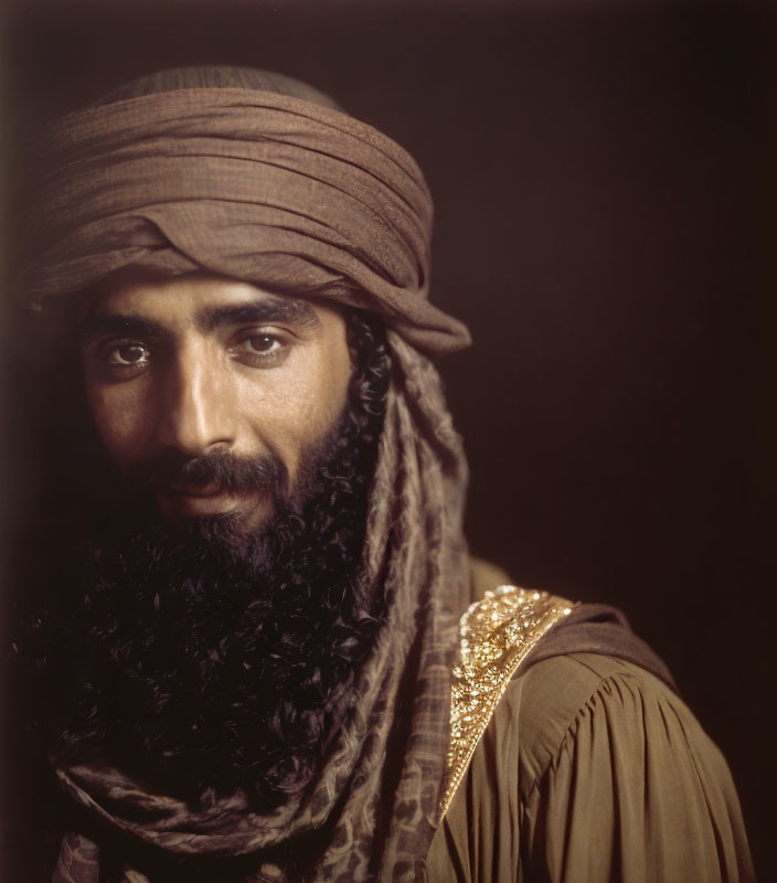 Bearded man in turban and embroidered garment portrait.