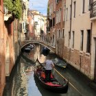 Historic Venetian canal with gondolas and flowering vines