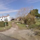 Serene rural landscape with white house, green hills, trees