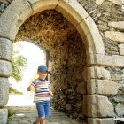 Ancient stone archway with remnants of doorframe and tree view