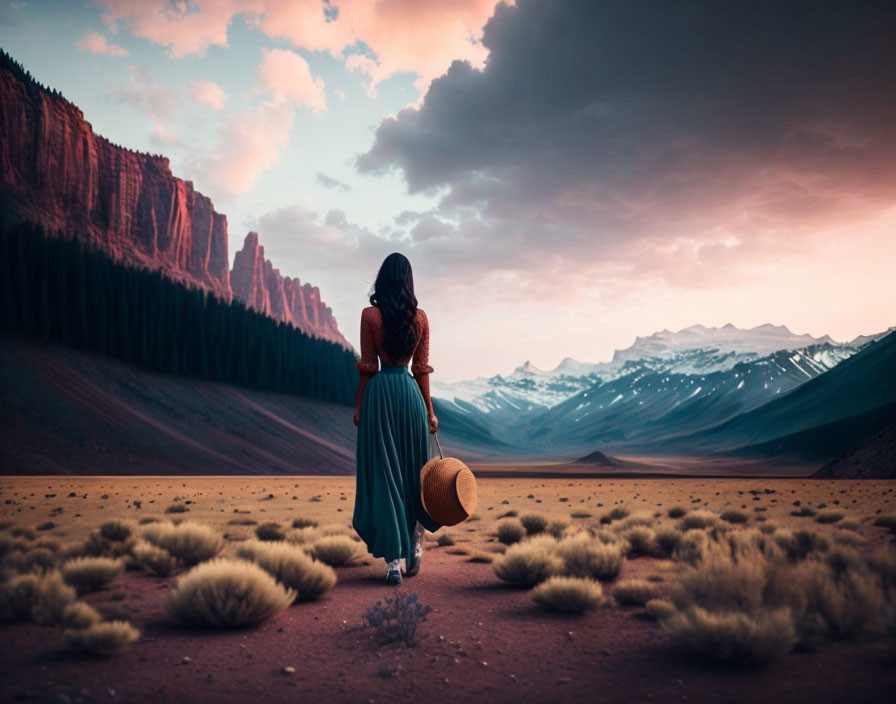 Woman in long dress holding hat in desert at twilight with mountains.