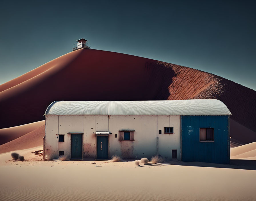 Desolate house buried in sand dunes under clear sky