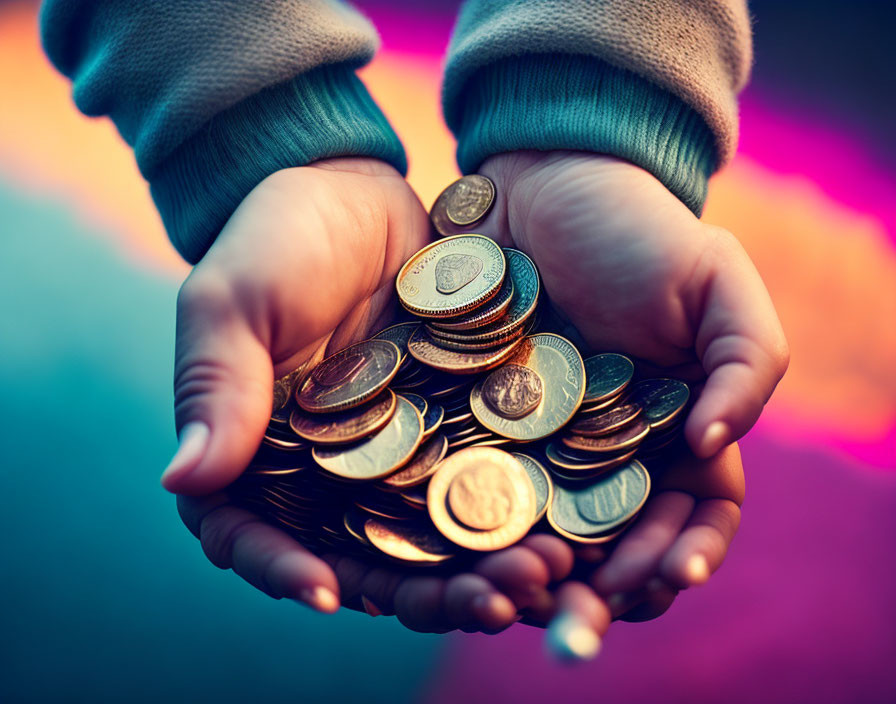 Hands holding coins against colorful backdrop