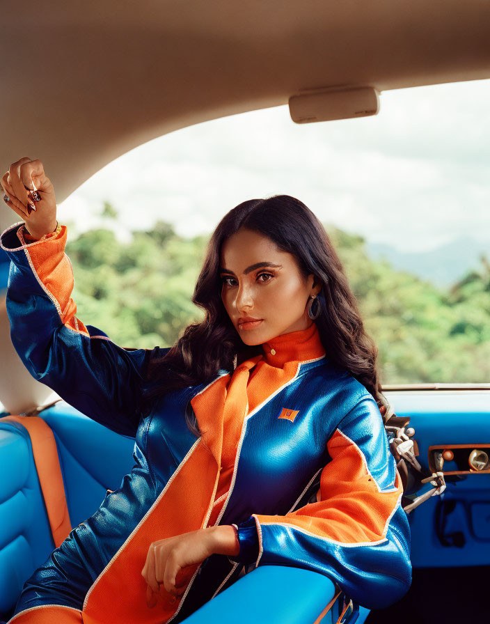 Woman in Vibrant Orange and Blue Outfit Posing in Car with Scenic Background