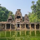 Ancient temple ruins in lush greenery near water