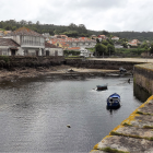 Picturesque riverside village with moored boats, blooming flowers, and historic architecture