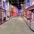 Whimsical cobblestone alley with hanging signs under twilight sky