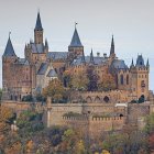 Majestic castle with spires in green landscape and red flowers