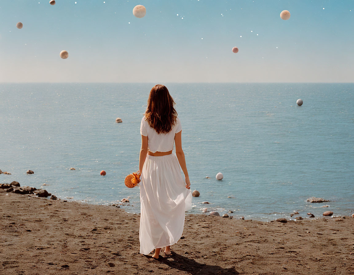 Woman in white dress on sandy beach with orbs in sky