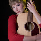 Mystical woman with guitar, elegant jewelry, and tattoos in dark setting