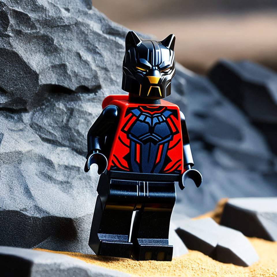 Superhero Lego figure in black and red costume on sandy surface