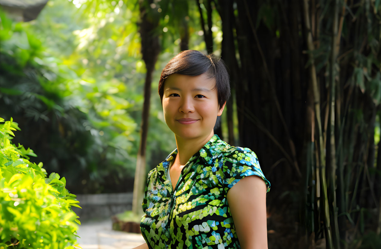 Smiling woman in green blouse surrounded by lush greenery