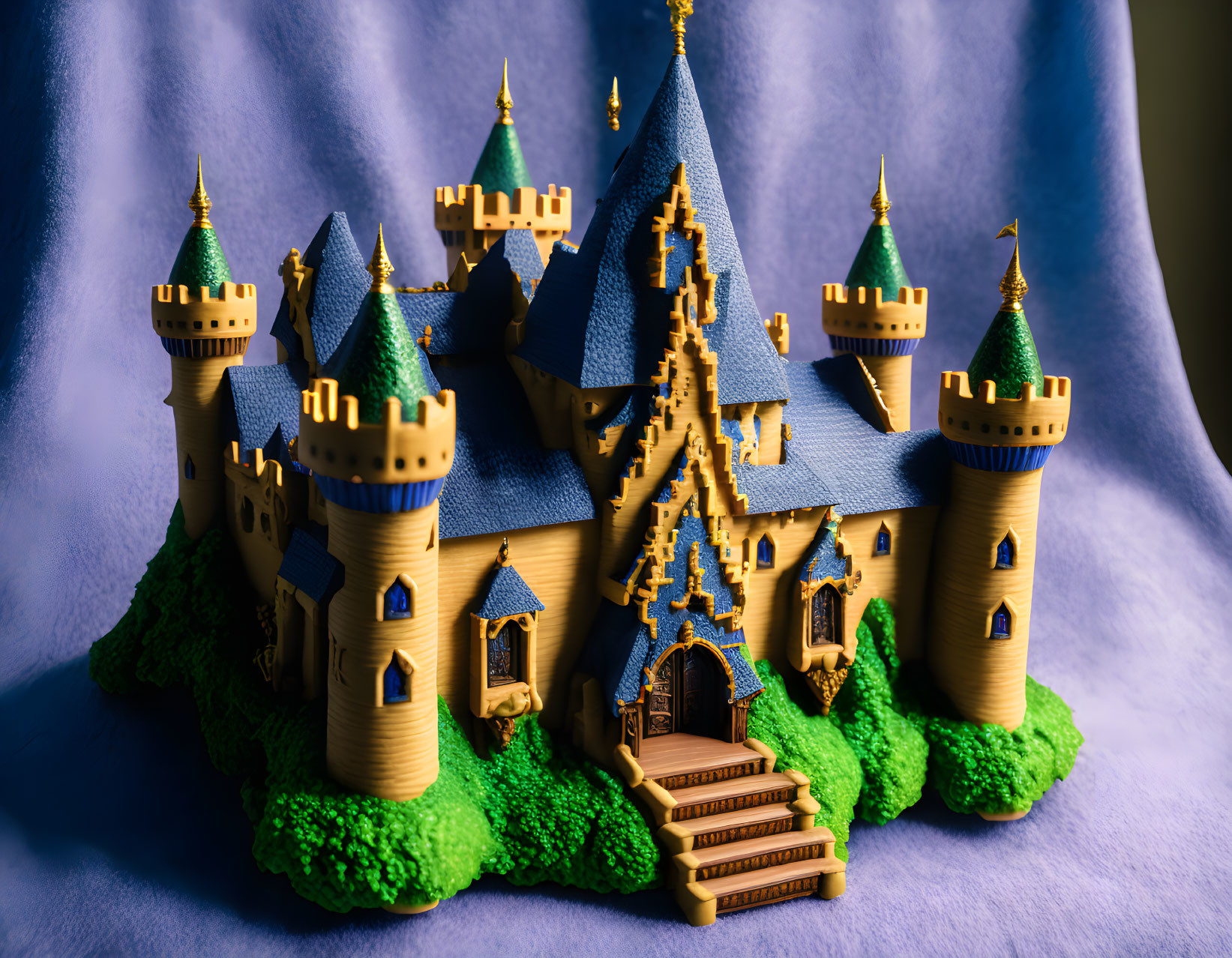 Detailed Fairytale Castle Model with Blue Roofs and Golden Spires on Green Landscape against Blue Dr