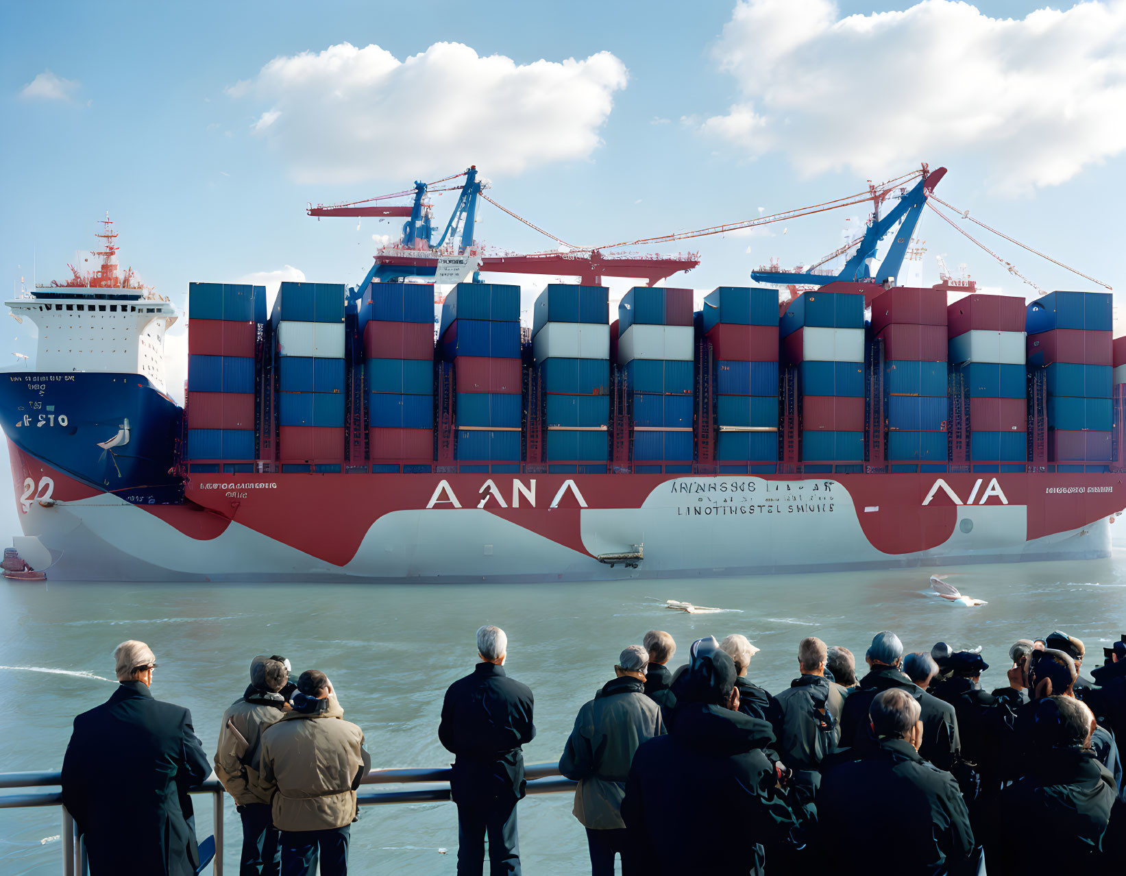 Crowd watching container ship and cranes under clear blue sky