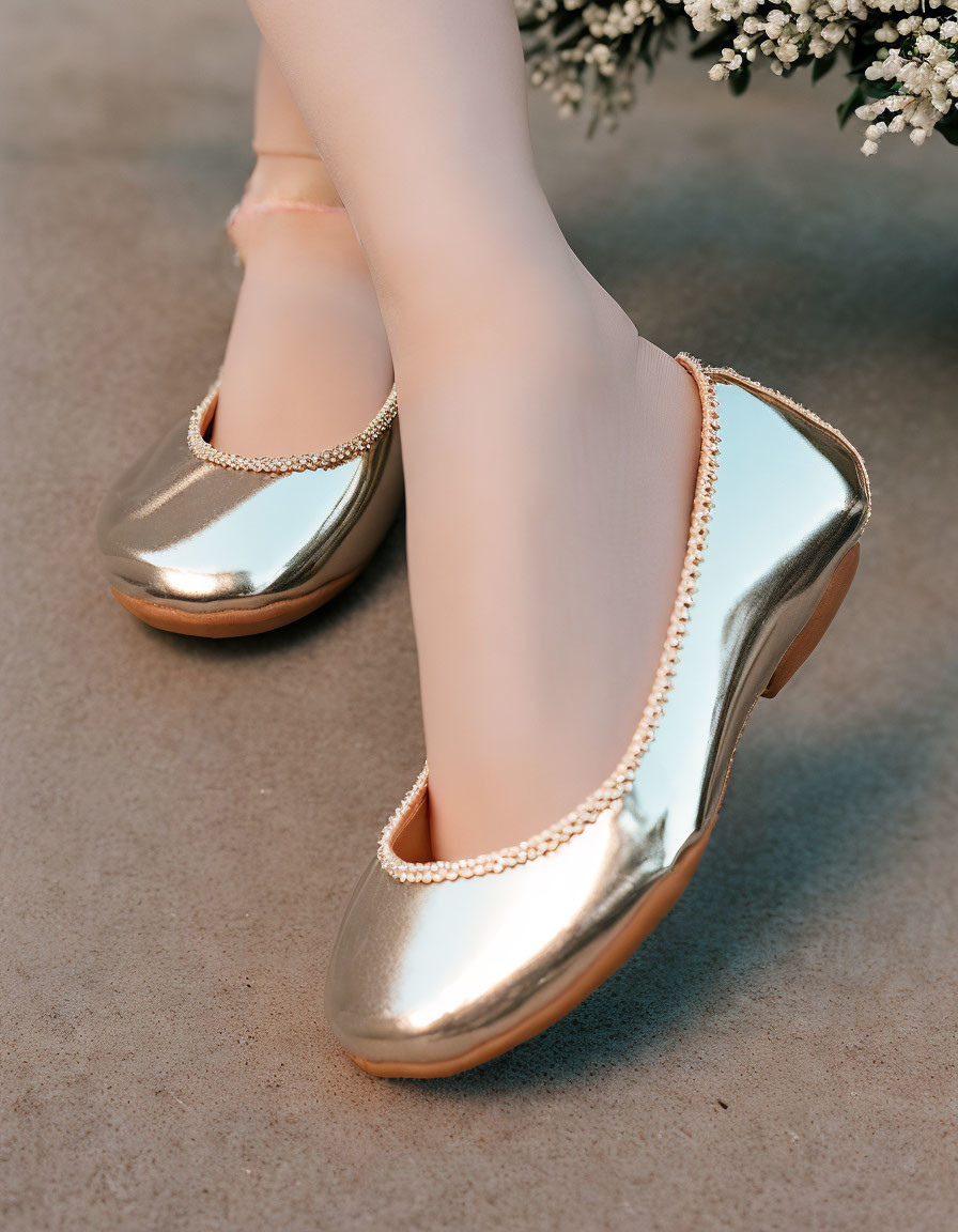 Gold Metallic Flats with Chain Adornment on Concrete Surface