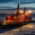 Icebreaker ship sailing through icy waters at twilight