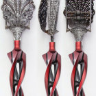 Three ornate fantasy daggers with intricate red details on blades