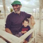 Smiling man and child in wheat field with paper roll