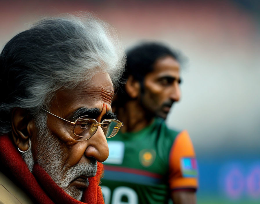 Grey-Haired Elderly Man with Glasses and Younger Man in Blurred Background