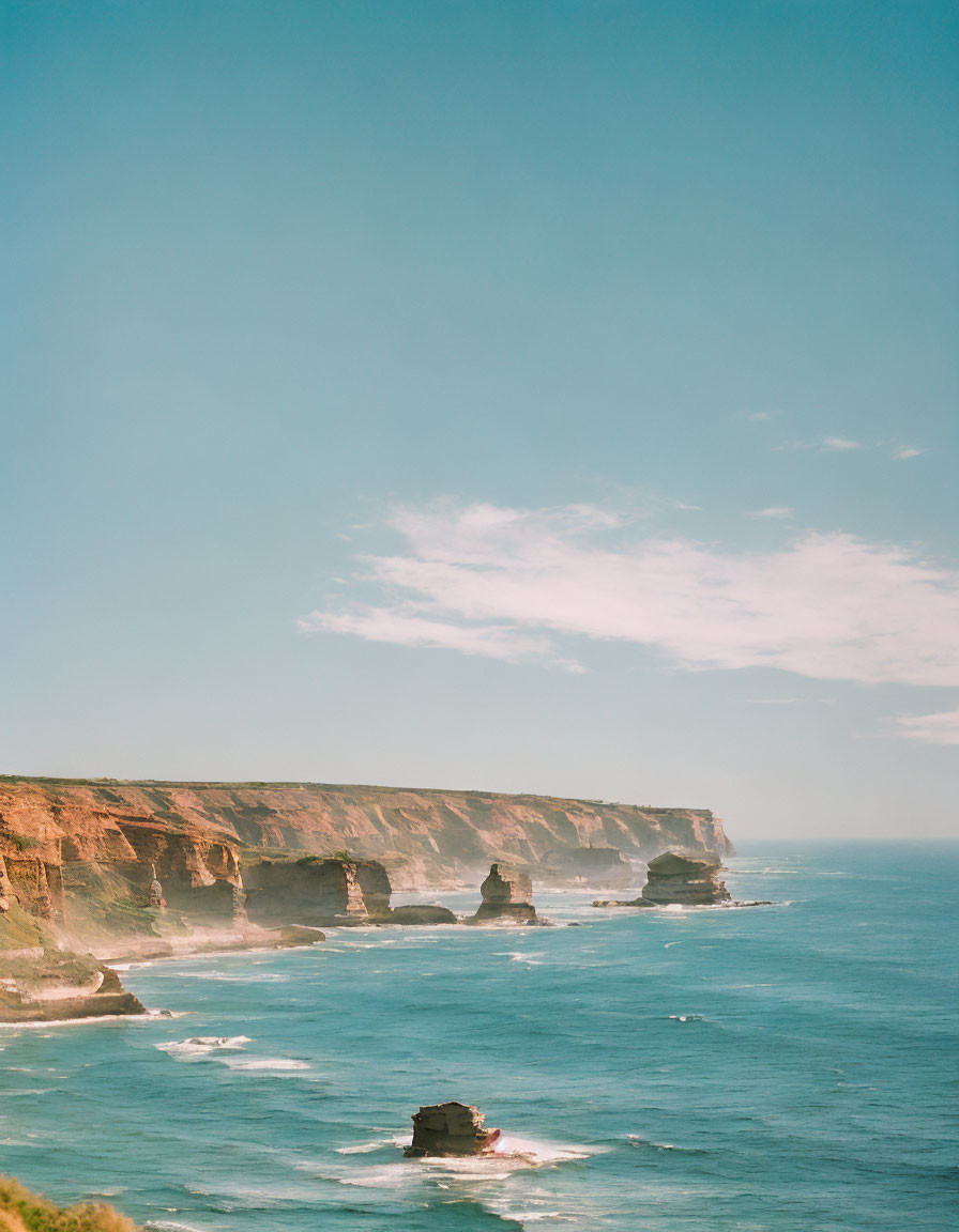 Coastal cliffs overlooking calm blue sea and rock formations