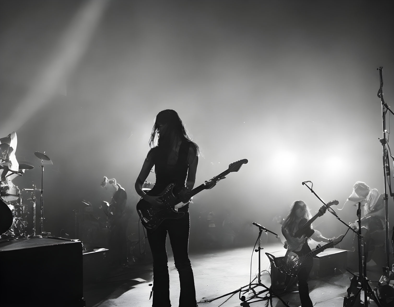 Monochrome silhouette of rock band on stage with dramatic lighting