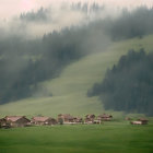 Scenic village nestled in misty valley with pink sky