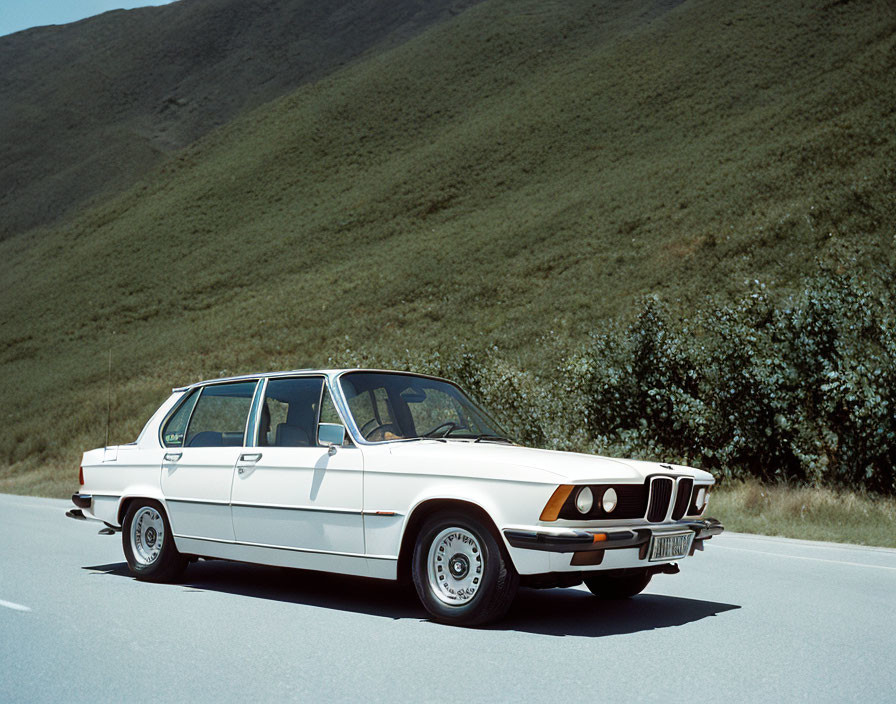 Vintage White BMW Car Parked by Grass-Covered Hill