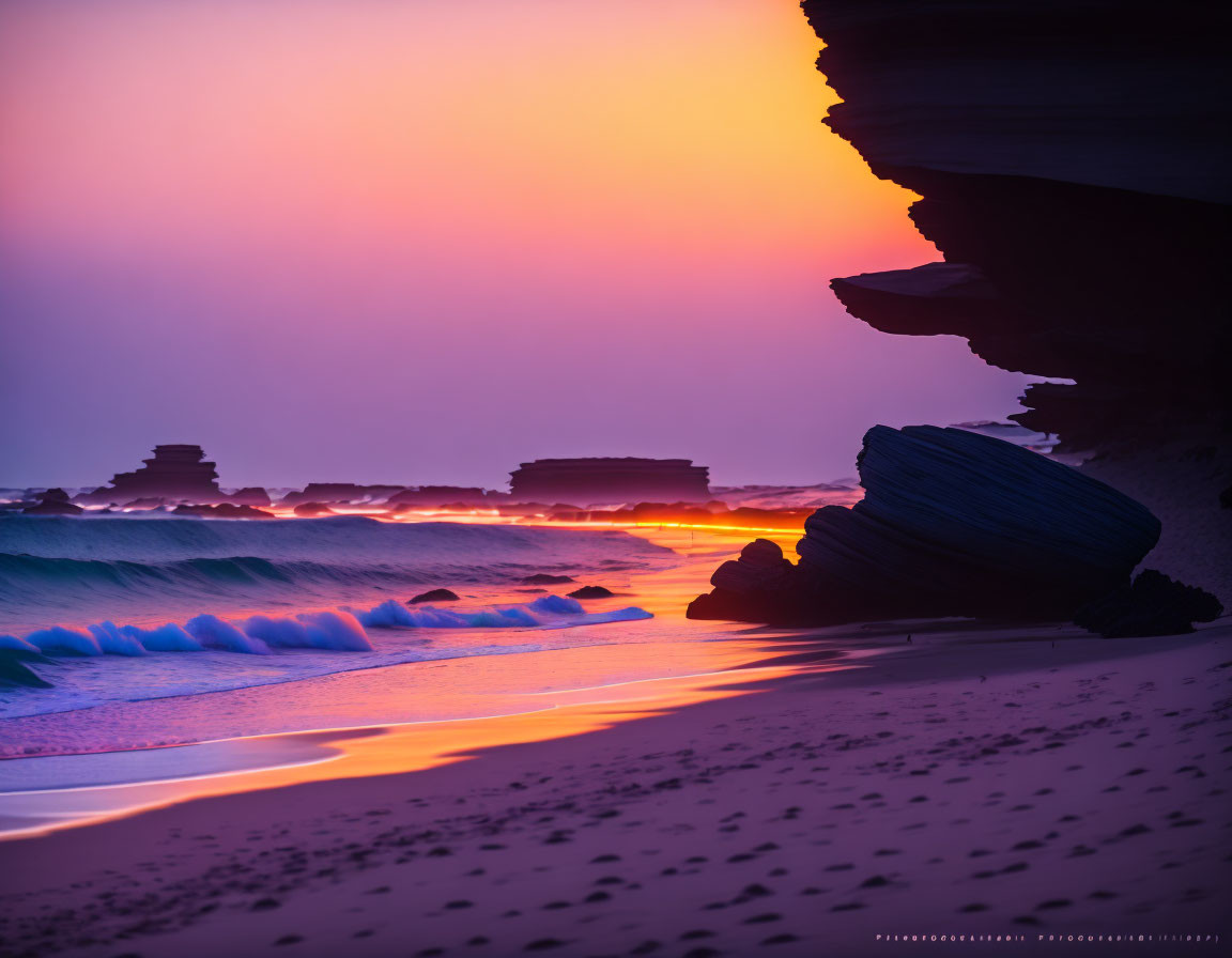 Serene beach at sunset with purple and orange glow