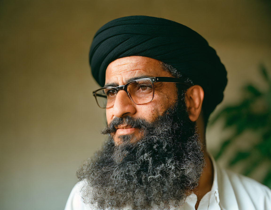 Bearded Man in Glasses with Black Turban and Blurred Background