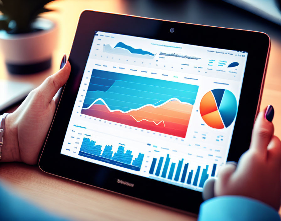 Person analyzing colorful charts and graphs on tablet screen