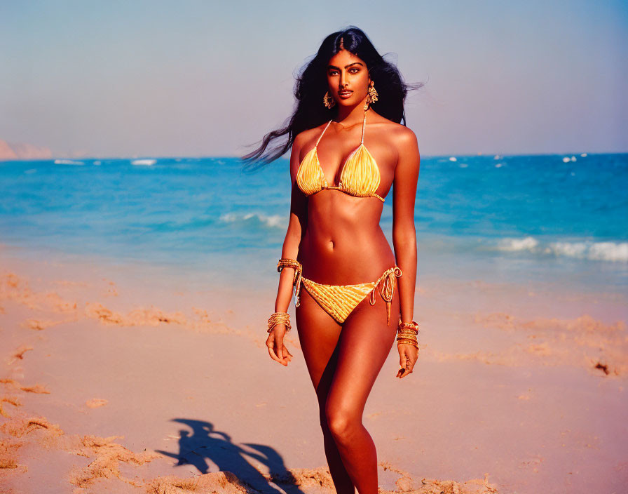 Woman in Gold Bikini on Beach at Golden Hour