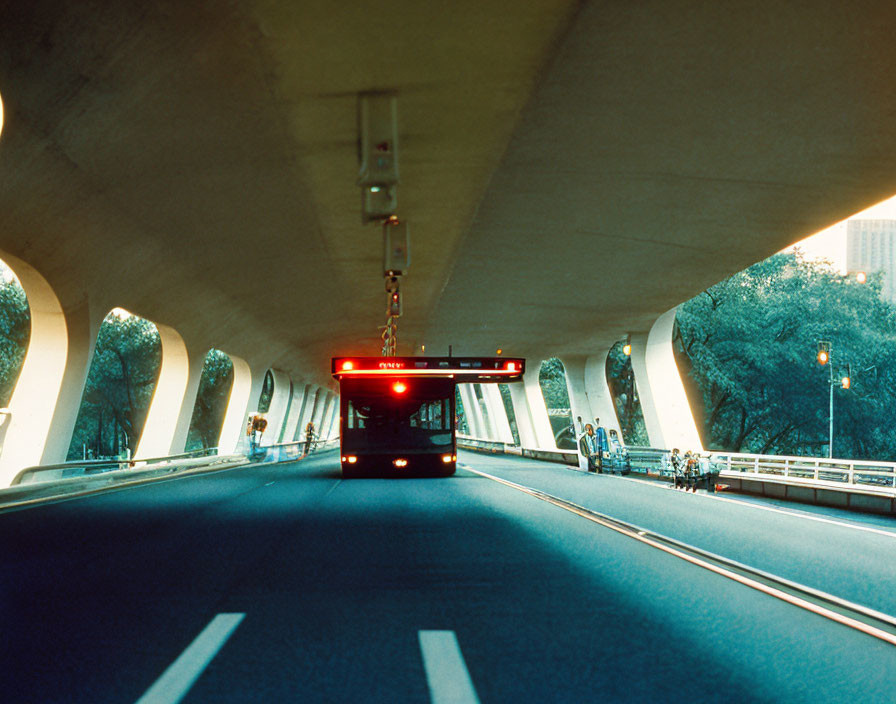 Red Bus in Modern Urban Tunnel with Arched Openings